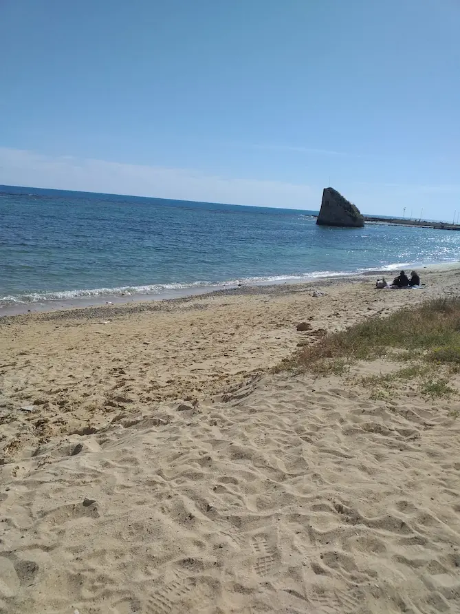 Tratto di costa di Torre Pali con la torre aragonese, mare calmo e sabbia dorata, ideale per vacanze rilassanti