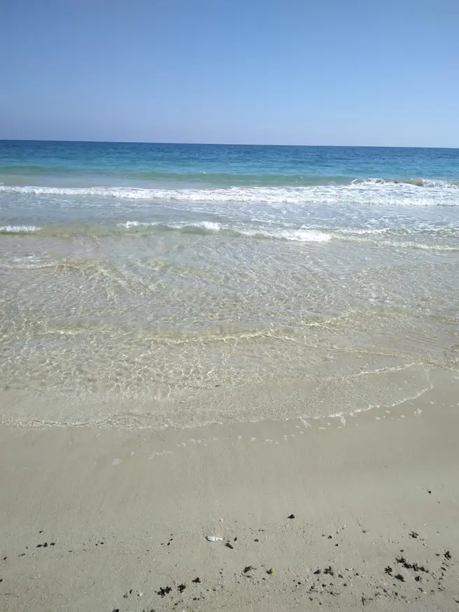 Vista frontale del mare azzurro e della spiaggia di Torre Pali