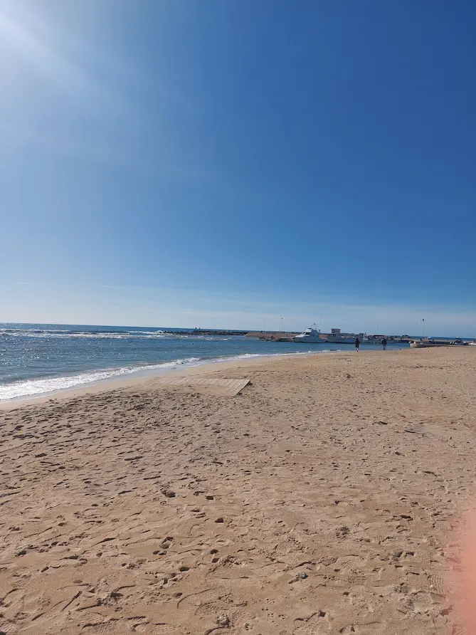 Vista panoramica della spiaggia e del mare di Torre Pali, Salento, con il molo sullo sfondo